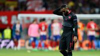 Pemain Arsenal, Alexandre Lacazette meninggalkan lapangan dengan tetrunduk usai kalah dari Atletico Madrid pada leg kedua semifinal Liga Europa di Wanda Metropolitano, Kamis (3/5). Arsenal tersingkir dari Liga Europa setelah kalah 0-1. (AP/Francisco Seco)