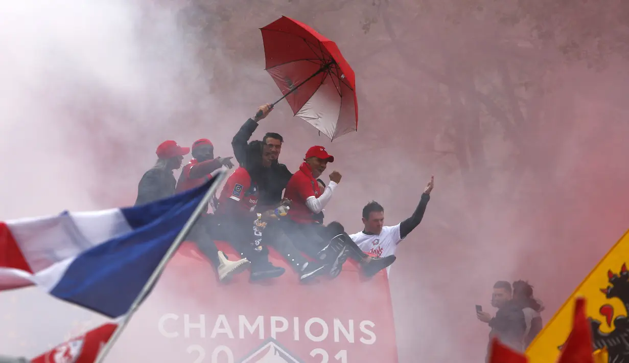 Para pemain Lille melambai kepada para penggemar dari atas bus atap terbuka saat merayakan juara Juara Ligue 1 Prancis di Lille, Prancis utara (24/5/2021). Ini merupakan gelar Ligue 1 keempat sepanjang sejarah Lille. (AP Photo/Michel Spingler)