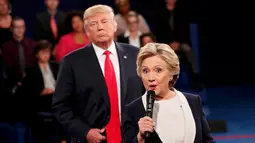Calon Presiden Partai Republik, Donald Trump saat mendengarkan Hillary Clinton menjawab pertanyaan dari penonton selama debat putaran kedua di Washington University, St Louis, AS, Minggu (9/10). (REUTERS/Rick Wilking)