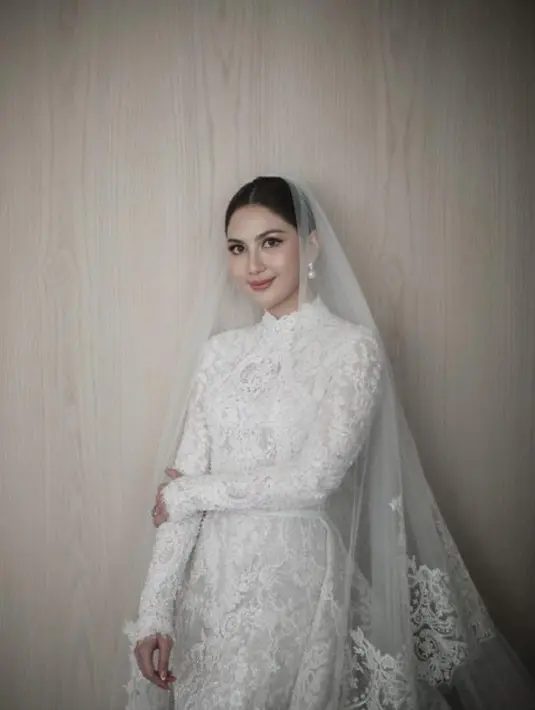 Jessica Mila tampil dengan gaun pernikahan putih model high neck lengan panjang brokat lengkap dengan veilnya dari Yefta Gunawan. [@jscmila]