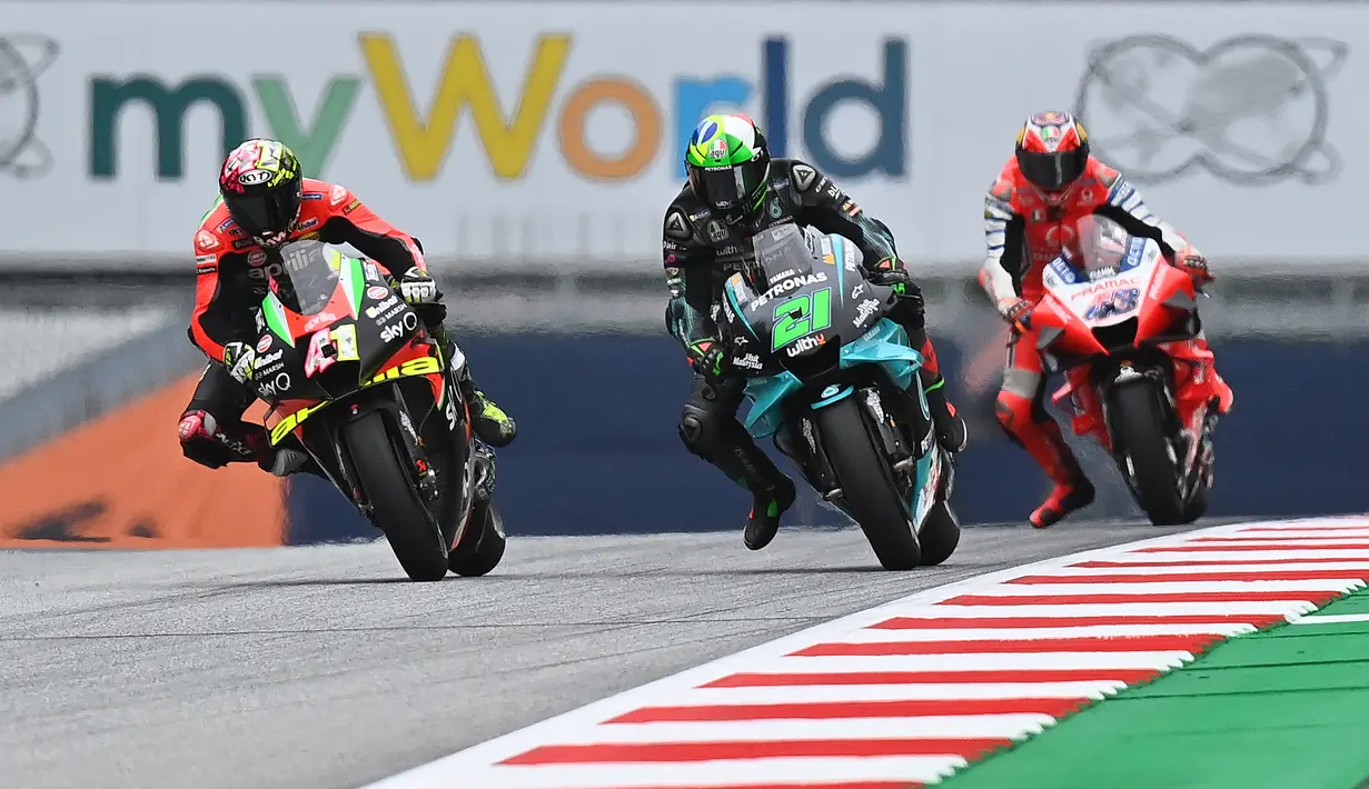 Pembalap Aprilia Racing, Aleix Espargaro, bersaing dengan Franco Morbidelli saat latihan cepat (FP3) MotoGP Austria di Sirkuit Red Bull Racing, Spielberg, Sabtu (15/8/2020). Vinales keluar sebagai rider tercepat pada sesi FP3 MotoGP Austria. (AFP/Joe Klamar)