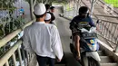 Pengendara sepeda motor melintasi Jembatan Penyeberangan Orang (JPO) di kawasan Pasar Minggu, Jakarta, Jumat (17/7/2020). Rendahnya kesadaran dalam disiplin berkendara menyebabkan sejumlah pengendara sepeda motor melintasi JPO tersebut meski merugikan pengguna lain. (Liputan6.com/Immanuel Antonius)