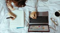Ilustrasi menulis, teks argumentasi. (Foto oleh Ketut Subiyanto: https://www.pexels.com/id-id/foto/laptop-buku-catatan-perempuan-tempat-tidur-4132345/)