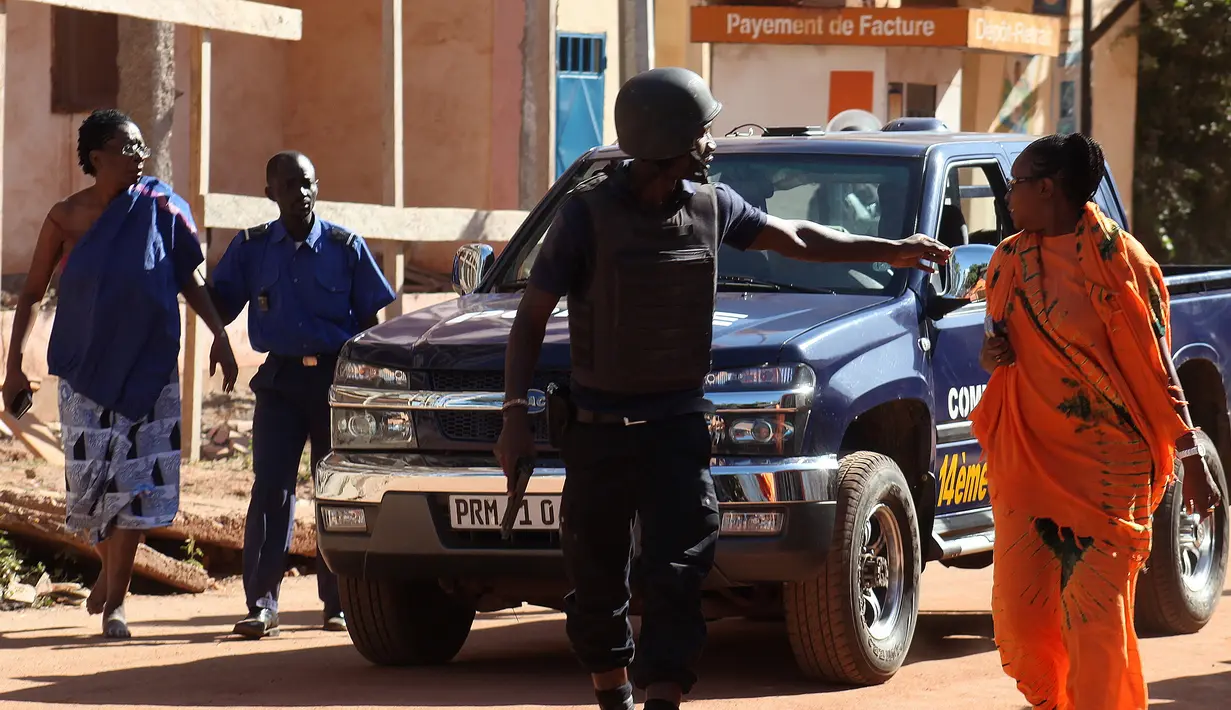Pasukan keamanan Mali mengevakuasi dua wanita yang menjadi sandera di Hotel Radisson Blu di Bamako, Jumat (20/11). Kelompok militan Islam menyerbu hotel mewah tersebut dan  menyandera lebih dari 100 orang tamu serta staf hotel. (AFP PHOTO/Habibou Kouyate)