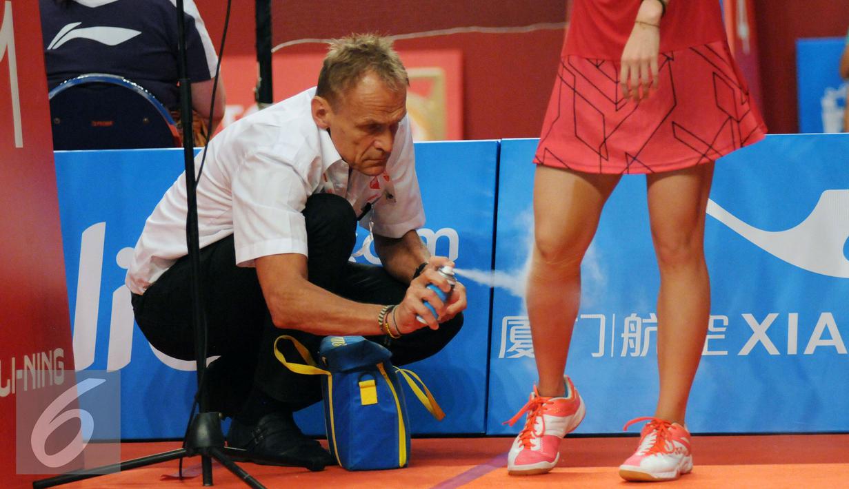 Tim medis menyemprotkan obat ke kaki pebulutangkis Thailand, Ratchanok Intanon saat berlaga melawan Lindaweni Fanetri (Indonesia) di Total BWF Championships 2015 di Jakarta, Kamis (13/8/2015). (Liputan6.com/Helmi Fithriansyah)