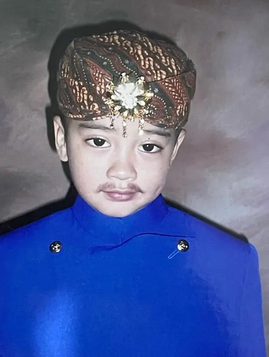 Potret Abidzar menegenakan pakaian adat waktu sekolah di Taman Kanak Kanak. Mengenakan beskap lengkap dengan blankon di kepala. Banyak netizen yang menyebutnya ganteng sejak kecil. [Instagram/abidzar73]