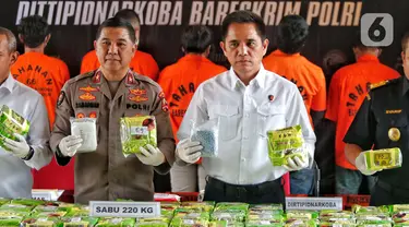 Direktur Tindak Pidana Narkoba Bareskrim Polri Brigjen Pol Krisno Halomoan Siregar (kemeja putih) menunjukkan barang bukti sabu dan  ekstasi di Mabes Polri, Jakarta, Rabu (22/2/2023). Bareskrim Polri menggagalkan upaya peredaran narkotika jenis sabu jaringan Malaysia dengan mengungkap dua kasus peredaran narkotika di wilayah Sulawesi Selatan dan Aceh sepanjang Februari 2023. (Liputan6.com/Angga Yuniar)