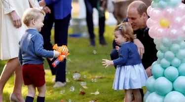 Pangeran George dan Putri Charlotte terlihat bergembira saat bermain pistol gelembung sabun dalam sebuah pesta untuk anak-anak di Government House di Victoria, British Columbia, Kanada, (29/9). (REUTERS/Chris Wattie)