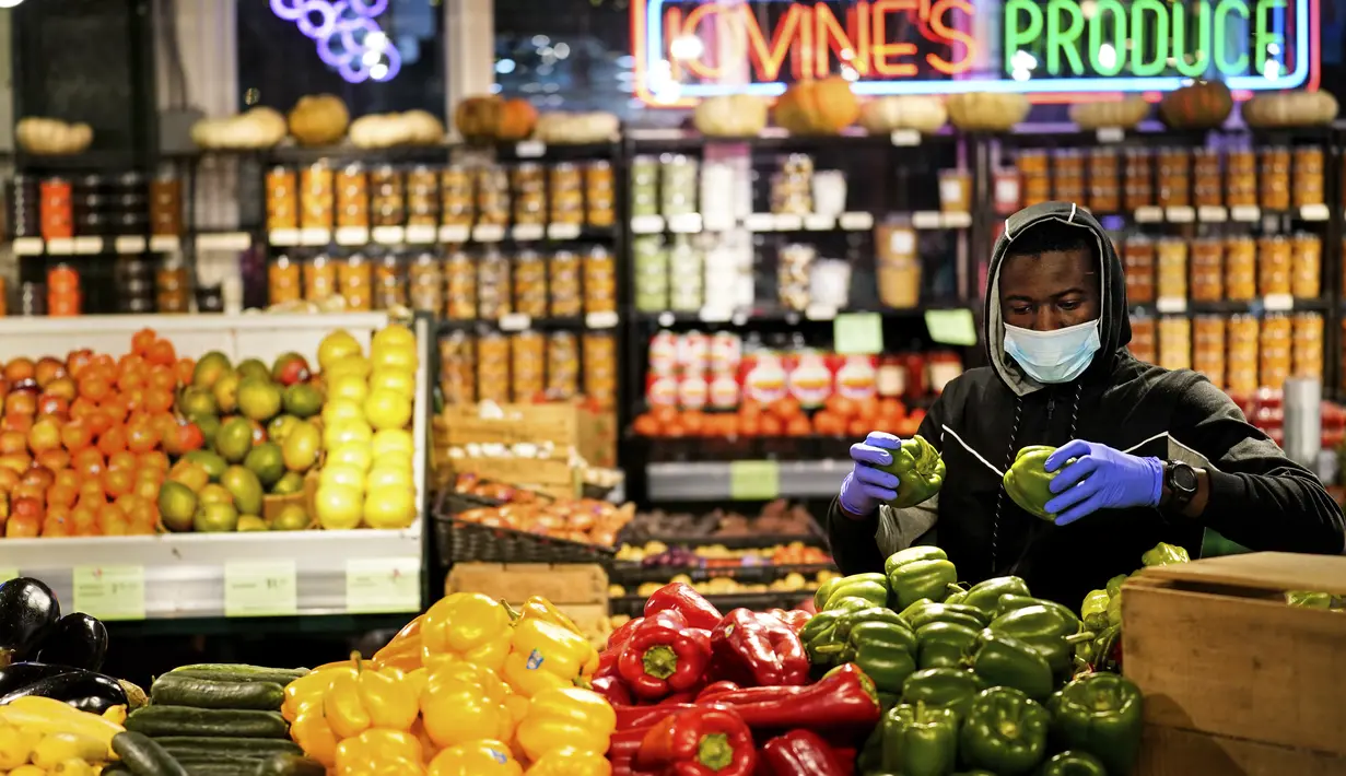 Seorang pembeli memilih buah di Reading Terminal Market di Philadelphia, Rabu (16/2/2022). Pejabat kota Philadelphia mencabut mandat vaksin untuk makan di dalam ruangan dan tempat lain yang menyajikan makanan dan minuman, tetapi mandat masker dalam ruangan tetap berlaku. (AP Photo/Matt Rourke)