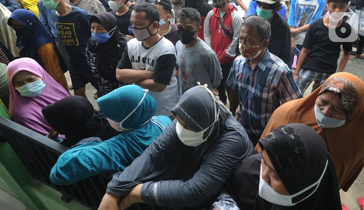 Warga menunggu giliran menerima uang Bantuan Sosial Tunai (BST) bulan Januari di halaman Masjid Jami Al-Hidayah RW 01 Bedahan, Depok, Selasa (16/2/2021). Sekitar 159.470 Keluarga Penerima Manfaat di Kota Depok menerima BST yang disalurkan PT Pos Indonesia pada Februari ini. (merdeka.com/Arie Basuki)