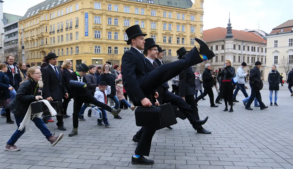 Sejumlah pria mengenakan kostum berwarna hitam berjalan di Brno, Republik Ceko (7/1). Monty Python memiliki acara televisi yang sangat berhasil pada tahun 1969 sampai 1974 yaitu Monty Python's Flying Circus. (AFP Photo/Radek Mica)