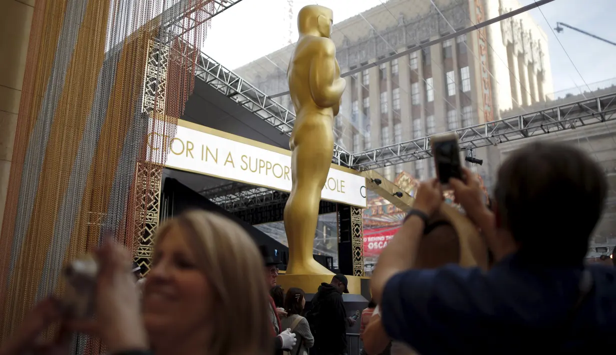Seorang pengunjung mengambil gambar dari patung Oscar 2016 di luar Teater Dolby, Hollywood, California, Jumat (26/2). Acara penghargaan Academy Awards ke-88 ini akan berlangsung pada Minggu (28/2) waktu setempat. (REUTERS/Lucy Nicholson)