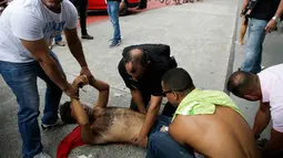 Polisi sipil menahan penjarah setelah mereka ditembak di kakinya di Vitoria, negara bagian Espirito Santo, Brasil, (7/2). Kejahatan Espirito Santo meningkat setelah polisi mogok kerja. (AP Photo / Diego Herculano)