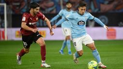 Pemain Valencia Carlos Soler (kiri) berebut bola dengan pemain Celta Vigo Fran Beltran pada pertandingan Liga Spanyol di Stadion Balaidos, Vigo, Spanyol, 5 Desember 2021. Valencia menang 2-1. (MIGUEL RIOPA/AFP)