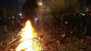 Pengunjuk rasa Lebanon membakar sampah dan ban selama protes terhadap tindakan penguncian yang ketat di Tripoli, Lebanon  (26/1/2021). Bentrokan terjadi di Lebanon utara antara pasukan keamanan dan demonstran yang marah karena lockdown (penguncian) terkait penanganan pandemi Covid-19.  (AP/STR)
