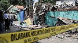 Petugas kepolisian saat memeriksa rumah rusak akibat tertimpa crane di kawasan Kemayoran, Jakarta, Kamis (6/12). Akibat kejidan tersebut menyebabkan tiga orang luka-luka. (Merdeka.com/Iqbal S. Nugroho)