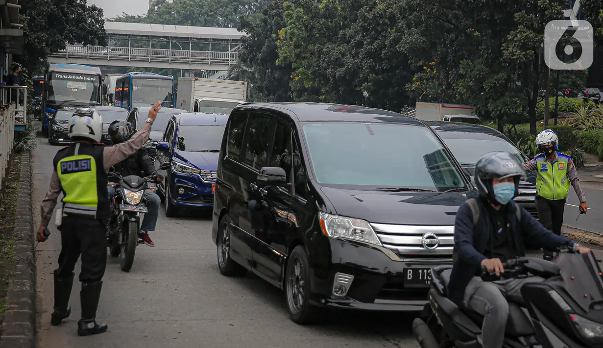 Anggota polisi melakukan penindakan kepada sebuah kendaraan saat ganjil genap di kawasan Jalan D.I Panjaitan, Jakarta, Senin (6/6/2022). Perluasan ganjil genap Jakarta tersebut dilakukan karena volume kendaraan meningkat di Ibu Kota RI tersebut ditiadakan. (Liputan6.com/Faizal Fanani)