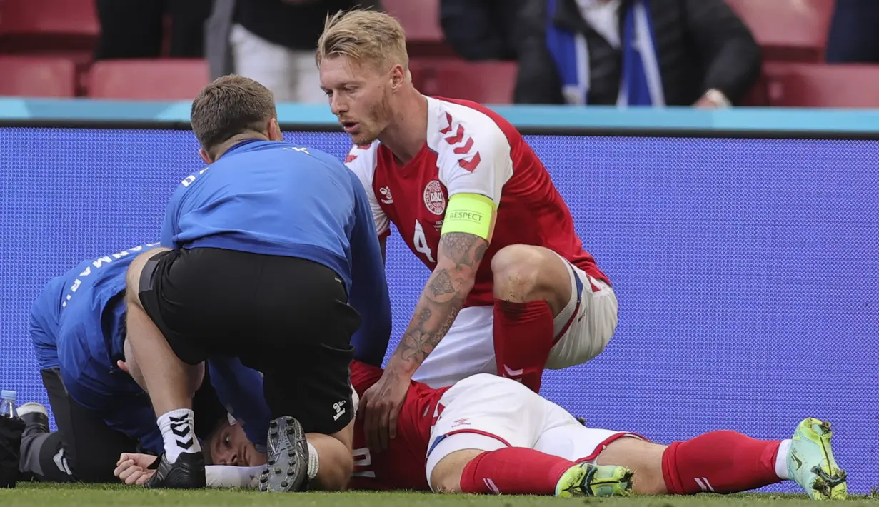 Gelandang Denmark, Christian Eriksen tergeletak di tanah setelah pingsan pada laga Denmark vs Finlandia di Grup B Euro 2020 di Parken Stadium, Copenhagen, Sabtu (12/6/2021). Laga dihentikan jelang berakhirnya babak pertama setelah Christian Eriksen pingsan. (Friedemann Vogel/Pool via AP)