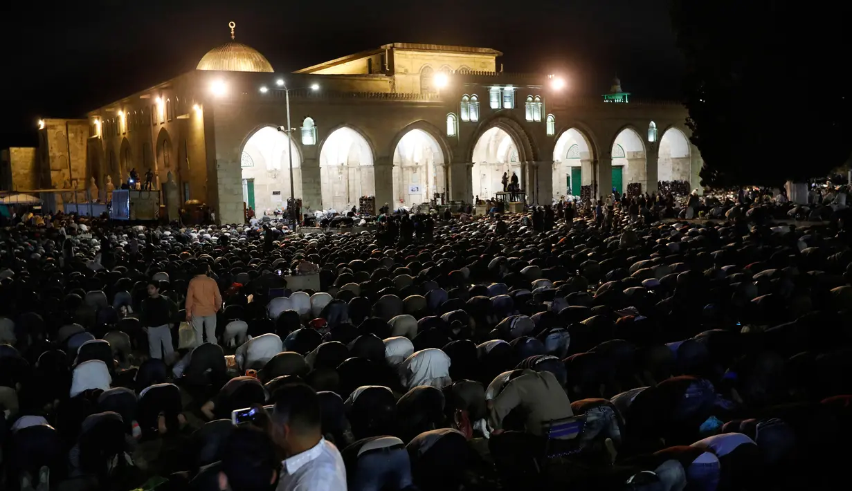 Muslim Palestina memanjatkan doa sambil menunggu Lailatul Qadar di luar Dome of the Rock, kompleks masjid Al-Aqsa di Kota Tua Yerusalem, Senin (11/6).Malam Lailatul Qadar juga disebut malam yang lebih baik daripada malam seribu bulan. (AFP/AHMAD GHARABLI)
