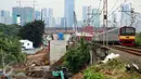 Kereta melintas di dekat pembangunan proyek double-double track (DDT) Paket A Manggarai-Jatinegara, Jakarta (3/3). Proses pengerjaan Paket A jalur Manggarai-Jatinegara terus di kebut sehingga ditargetkan selesai tahun 2019. (Liputan6.com/Johan Tallo)