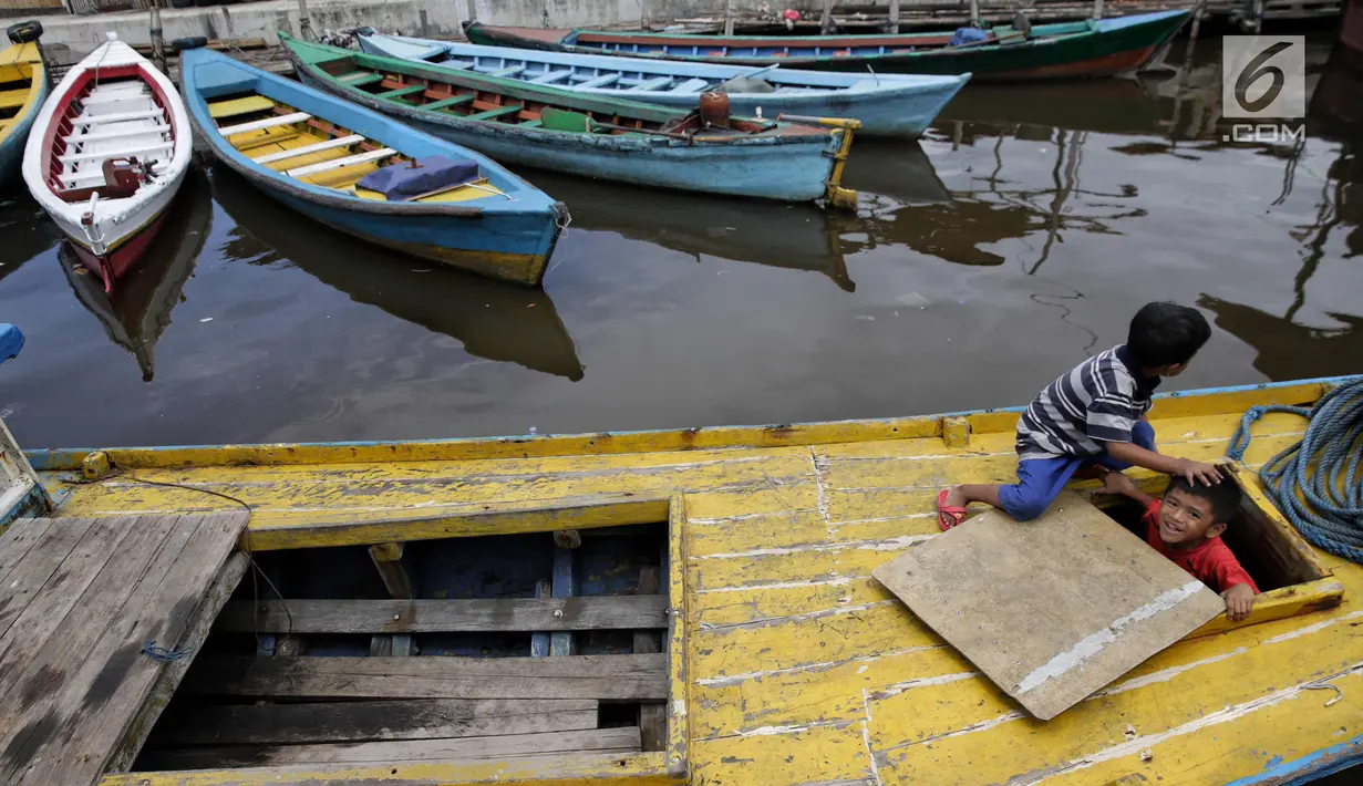 Dua orang anak bermain di atas perahu di kawasan Luar Batang Jakarta, Selasa (14/11). Minimnya fasilitas dan lahan bermain di wilayah tersebut memaksa anak-anak memanfaatkan kapal-kapal kayu dan perahu yang bersandar. (Liputan6.com/Faizal Fanani)