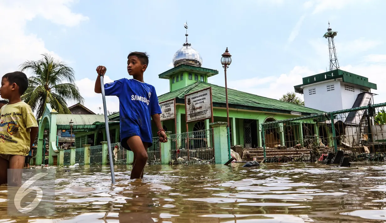 Bocah melintas di kawasan banjir di Perumahan Pondok Gede Permai (PGP) Jatiasih, Bekasi, Jawa Barat, Jumat (22/4). Ketinggian air mencapai 1,5 meter dari sebelumnya ketinggian mencapai hampir 4 meter. (Liputan6.com/Fery Pradolo)