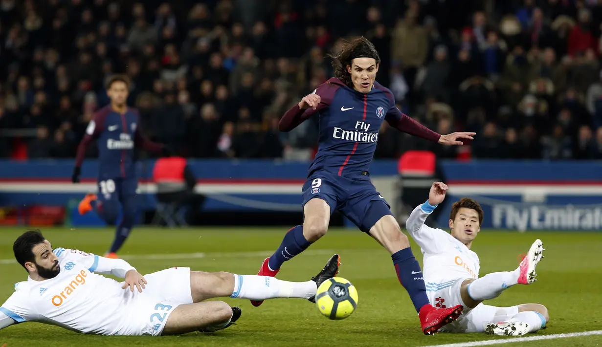 Aksi pemain PSG, Edinson Cavani melewati adangan dua pemain Marseille, Adil Rami (kiri) dan Hiroki Sakai pada lanjutan Ligue 1 Prancis di Parc des Princes Stadium, Paris, (25/2/2018). PSG menang 3-0. (AP/Thibault Camus)