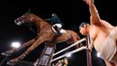 Marlon Modolo Zanotelli dari Brasil mengendarai Edgar M melewati patung pegulat sumo dalam kualifikasi individu lompat berkuda Olimpiade Tokyo 2020 di Equestrian Park di Tokyo (3/8/2021). Pihak panitia memasang patung simbol Jepang seperti sakura sampai pesumo di arena lintasan. (AFP/Behrouz Mehri)