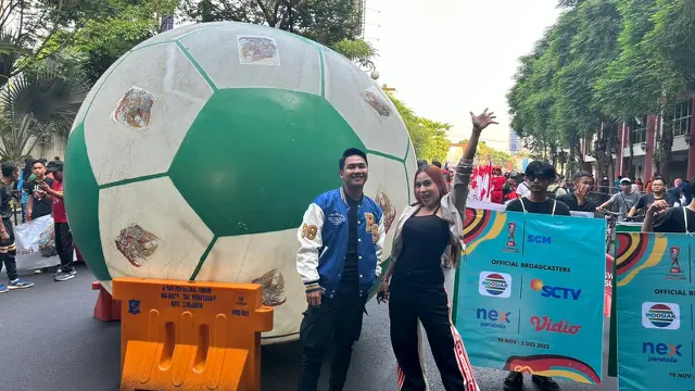 Ridwan Naibaho dan Lilis Darawangi Semangat Menggiring Bola Raksasa Sekaligus Menyapa Warga Surabaya di Area Car Free Day, Balai Pemuda, Surabaya.