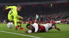 Pemain Arsenal, Danny Welbeck (kanan) jatuh saat berebut bola dengan kiper West Ham United, Joe Hart pada laga Piala Liga Inggris di Emirates Stadium, London, (19/12/2017). Arsenal menang 1-0. (AFP/Ben Sransall)