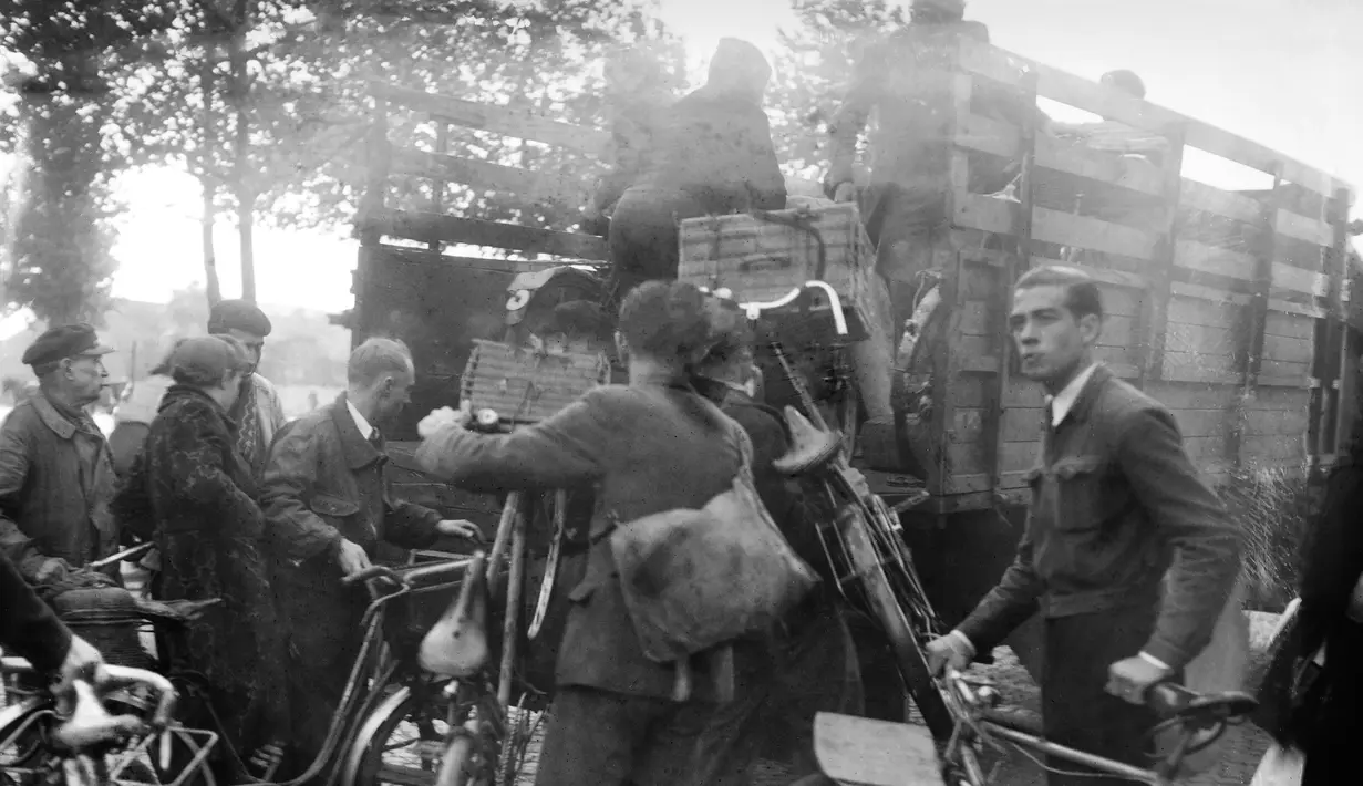 Warga Paris membawa sepeda menunggu giliran naik ke atas truk yang digunakan sebagai transportasi umum, pada Oktober 1944 di Paris, beberapa bulan setelah Pembebasan Paris, selama Perang Dunia Kedua. (AFP Photo)