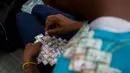 Wilmer Rojas (25) saat membuat tas dari lembaran mata uang Bolivar di Caracas, Venezuela, 30 Januari 2018. Inflasi yang tinggi membuat mata uang tersebut terus kehilangan nilainya. (AFP Photo/Federico Parra)