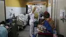 Perawat mengganti infus untuk pasien COVID-19 di lorong pintu masuk Rumah Sakit Umum, sementara ruangan klinik penuh di Luque, Paraguay, Jumat (11/6/2021). Menurut Kementerian Kesehatan Paraguay, negara itu telah melampaui 10.000 kematian terkait COVID -19 minggu ini. (AP Photo/Jorge Saenz)
