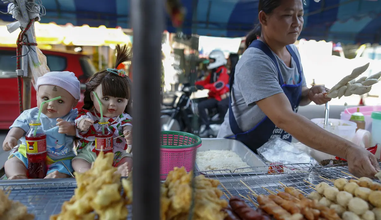 Seorang penjual memajang boneka Look Thep (anak malaikat) di atas meja jualannya di Nonthaburi, Selasa (26/1). Masyarakat Thailand tengah digandrungi boneka yang diisi dengan roh anak kecil melalui ritual tertentu tersebut (REUTERS/Athit Perawongmetha)