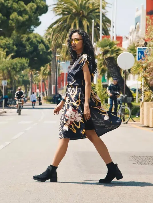 Penampilan edgynya itu disempurnakan dengan sepatu boots, kalung choker, dan kacamata warna kuning. (Instagram/deapanendra).