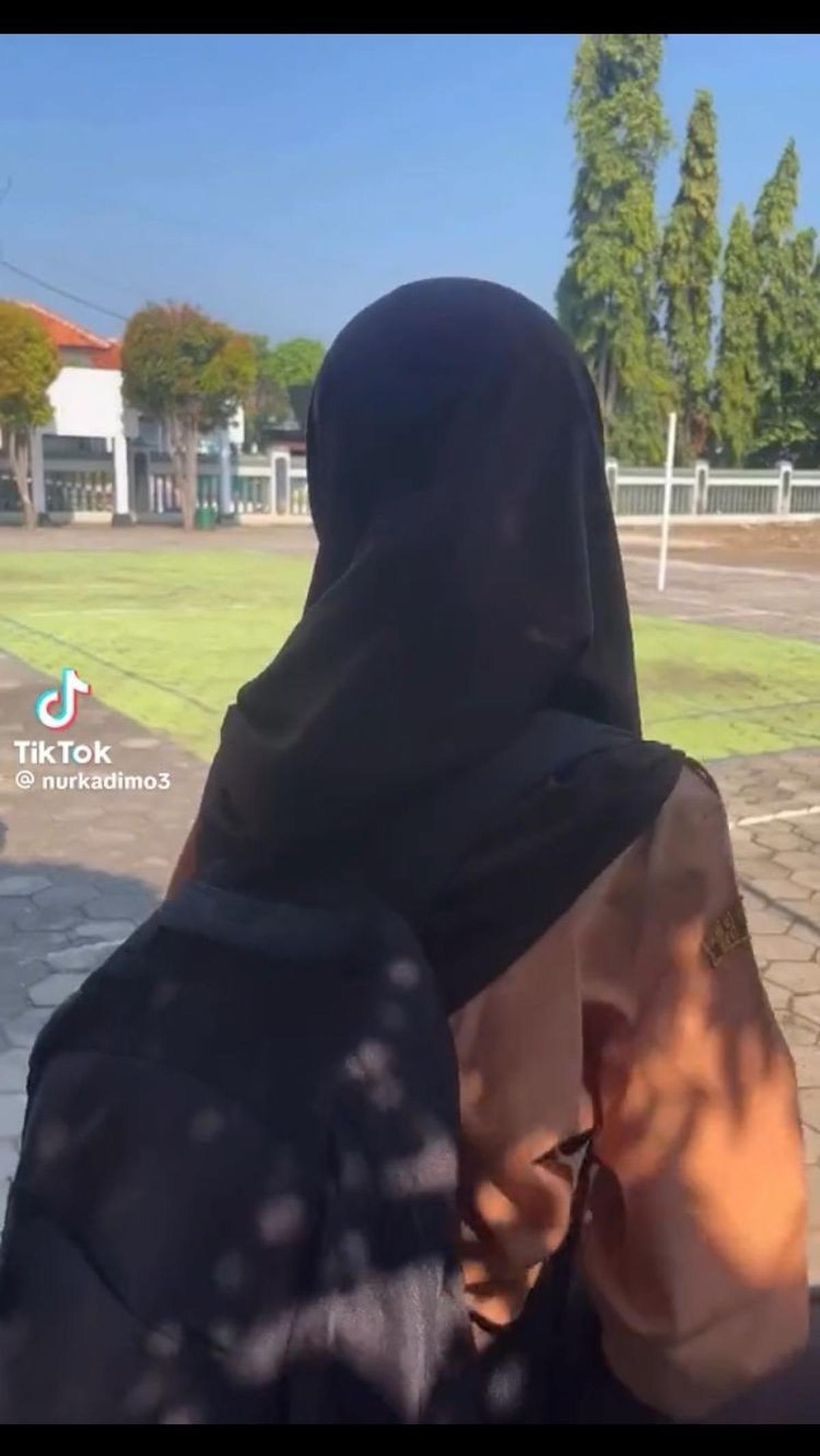 Awalnya, tampak sang anak sedang duduk di halaman sekolah menunggu jemputan.