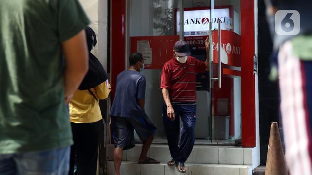 FOTO: Antrean Warga Cairkan Bantuan Sosial COVID-19