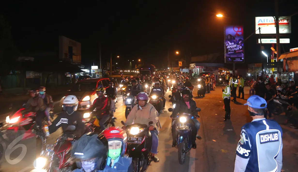 Sejumlah petugas memantau arus lalu lintas di jalur simpang Cikalong, Jawa Barat, Jumat (1/7) dini hari. H-5 Lebaran, ratusan pemudik yang menggunakan sepeda motor mulai memadati jalur pantura menuju Jawa Tengah. (Liputan6.com/Angga Yuniar)