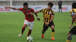 Pemain tengah Timnas Indonesia U-23, Syaiful Indra Cahya (kiri) berebut bola dengan M Nazmi Faiz Mansor (Malaysia U-23) saat laga uji coba di Stadion Si Jalak Harupat, Bandung, Kamis (21/5/2015). Indonesia unggul 1-0. (Liputan6.com/Helmi Fithriansyah)