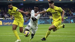 Penyerang Real Madrd, Vinicius Junior berusaha melewati dua pemain Villarreal, Raul Albiol dan Juan Foyth selama pertandingan lanjutan La Liga Spanyol di Estadio De La Ceramica di Villareal, Spanyol, Sabtu (7/1/2023). Kekalahan ini tidak mengubah posisi Real Madrid di peringkat dua klasemen sementara Liga Spanyol 2022-2023 dengan perolehan 38 poin. (AP Photo/Alberto Saiz)