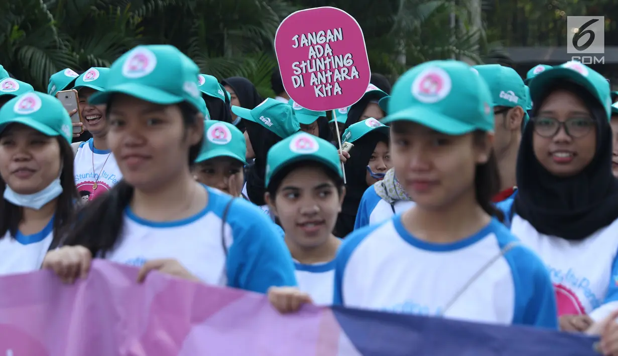 Peserta kampanye cegah stunting membawa tulisan saat berjalan di kawasan Bundaran Hotel Indonesia, Jakarta, Minggu (16/9). Kampanye ini bertujuan mengurangi penderita stunting di Indonesia. (Liputan6.com/Helmi Fithriansyah)