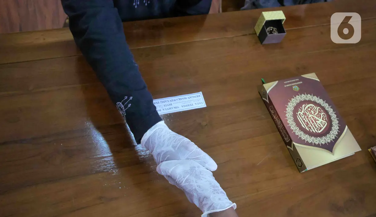 Pasangan Artahabayu dan Salwa saat melangsungkan pernikahan di KUA Kecamatan Meteng, Jakarta, Selasa (22/2/2022). Sejumlah pasangan sengaja melangsungkan pernikahan pada hari ini yang memiliki tanggal, bulan, dan tahun unik yakni 22-02-2022. (Liputan6.com/Herman Zakharia)
