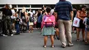 Anak-anak dan orang tua menunggu guru memanggil nama mereka pada hari pertama sekolah di sekolah dasar Condorcet di Lormont, di pinggiran Bordeaux, barat daya Prancis, Senin (4/9/2023). (Christophe ARCHAMBAULT / AFP)