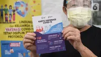 Dokter menunjukkan Kartu Vaksinasi Covid-19 usai divaksin di Puskesmas Cengkareng, Jakarta Barat, Selasa (9/2/2021). Vaksinasi Sinovac yang dilakukan secara paralel untuk tenaga kesehatan di atas 60 tahun dilakukan karena mereka rentan tertular virus Covid-19. (Liputan6.com/Fery Pradolo)