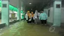 Petugas rumah sakit melintasi banjir yang menggenangi RS Islam Jakarta, Senin (9/2/2015). (Liputan6.com/Herman Zakharia)