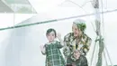 Dengan nuansa hijau, gayanya begitu menggemaskan. Sang anak kenakan dress bersiluet klasik disertai motif tartan yang menggemaskan. [Foto: Instagram/ Julie Estelle]