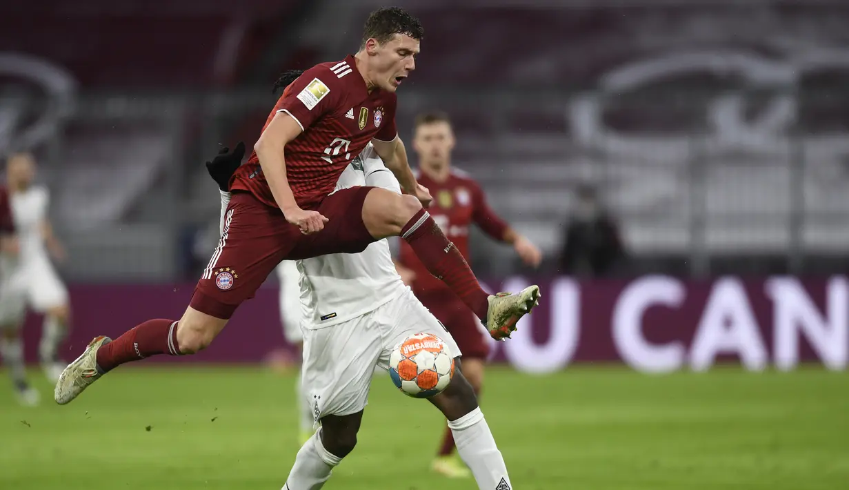 Bek Bayern Munchen Benjamin Pavard mengontrol bola dibayangi penyerang Borussia Monchengladbach, Breel Embolo pada laga pekan ke-18 Bundesliga di Allianz Arena, Sabtu (8/1/2022) dini hari WIB. Bayern Munchen dipermalukan di kandang sendiri 1-2. (AP Photo/Andreas Schaad)