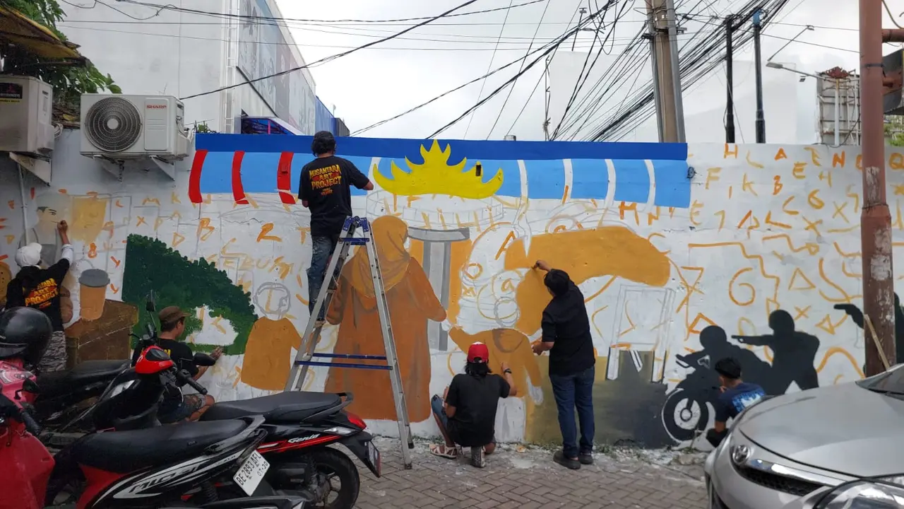 Seniman di Lampung membuat mural sebagai bentuk penghormatan atas gugurnya Bripka Arya Supena. (Liputan6.com/Ardi Munthe).