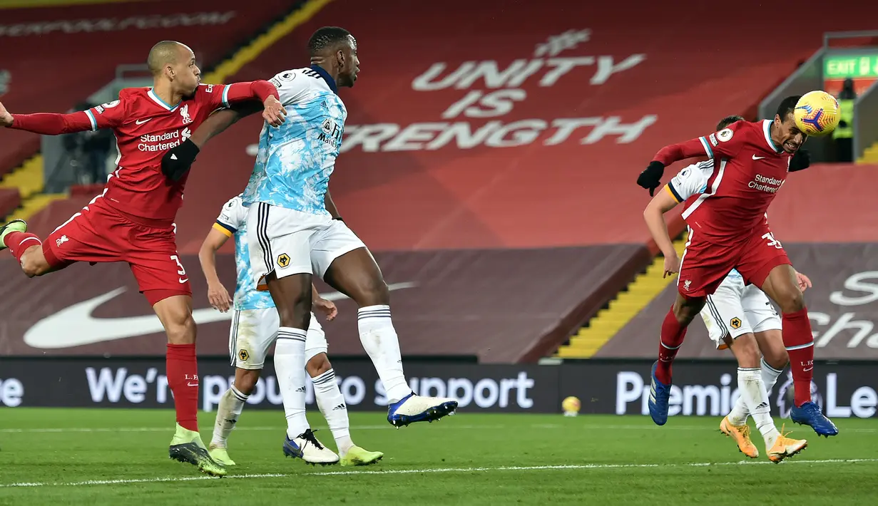 Bek Liverpool, Joel Matip (kanan), menanduk bola yang berbuah gol ketiga Liverpool ke gawang Wolverhampton dalam laga lanjutan Liga Inggris 2020/21 pekan ke-11 di Anfield Stadium, Minggu (6/12/2020). Liverpool menang 4-0 atas Wolverhampton. (Pool via AFP/Peter Powell)