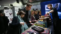 Peserta pameran memperkenalkan produk cokelat kepada pengunjung di Pameran Cokelat Brussel ketujuh di Brussel, Belgia (13/2/2020). Pameran ini mempertemukan lebih dari seratus pembuat cokelat, koki pastri, manisan, dan produsen kakao, dibuka pada Kamis (13/2) di ibu kota Belgia. (Xinhua/Zhang Cheng)